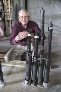 Leigh Bond of Threshold Energy shows off where the pipes for the geothermal heating system come into the house. These pipes will eventually be hooked up to a ground source heat pump.