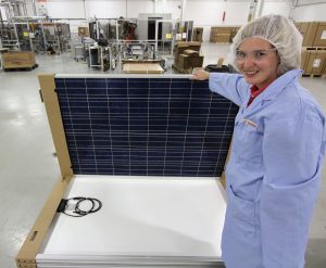 Suzanne Wilton shows off one of the panels that Canadian Solar manufactures.