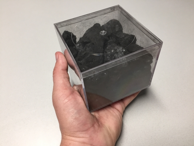 Austin Brown of the National Renewable Energy Lab keeps this hunk of coal on his desk as a reminder of what a kilowatt-hour of electricity actually is. Burning this softball sized piece of coal will give you roughly a kilowatt-hour worth of electricity. Photo courtesy of Austin Brown NREL. 